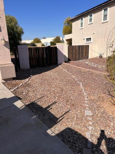 a driveway with a fence and a house at Goodyear 2 Story Room 3 in Goodyear