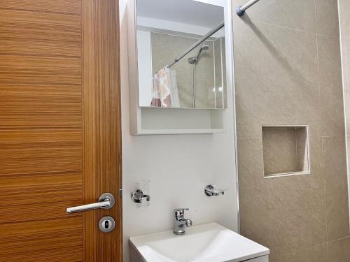 une salle de bain avec un lavabo et un miroir et des toilettes dans l'établissement Gray Fox Apartments - Martial, à Ushuaia