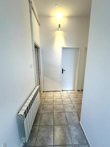 an empty hallway with a door and a tile floor at Apartment Oleander Garden in Biograd na Moru