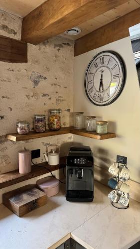 a kitchen with a clock on the wall and a toaster at Gîte entier - Alleu des Bois in Oyré