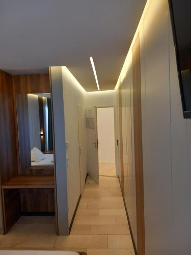 a hallway leading to a bedroom with a mirror at Hotel Hafez in Bad Salzuflen