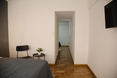 a room with a bed and two chairs and a hallway at El Misti Suites Buenos Aires in Buenos Aires