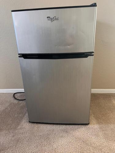 a stainless steel refrigerator in a corner of a room at Goodyear 2 Story Room 4 in Goodyear