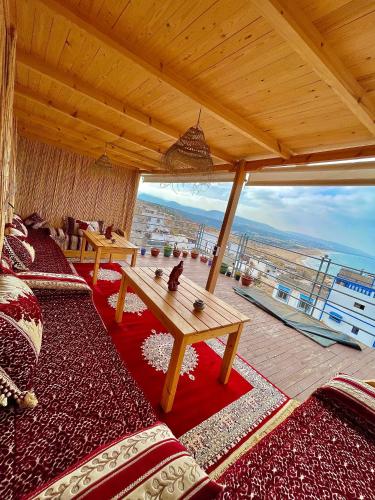 a living room with a table and a large window at Arinas Surf Hostel in Taghazout