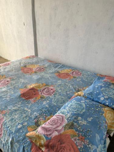 a bed with a quilt with roses on it at Pelican House in Rivas