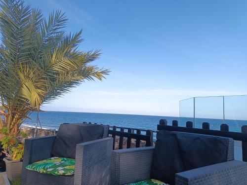 een paar stoelen op een balkon met uitzicht op de oceaan bij A Dream On The Beach Sun Club in Playa del Aguila