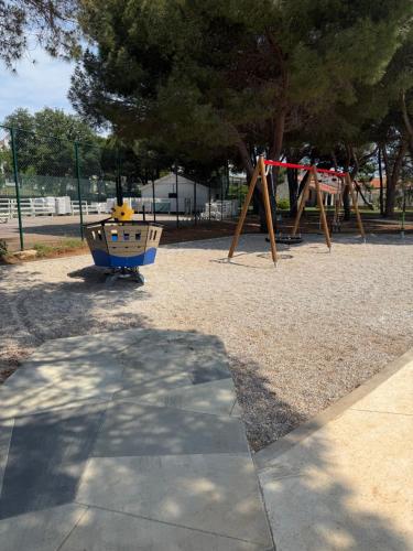 a park with a playground with a swing set at Apartman August in Medulin