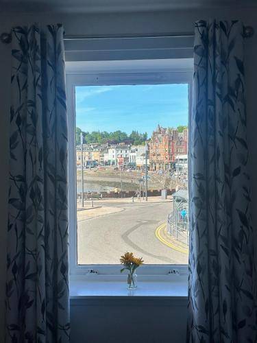 a window with a vase of flowers in a window sill at Kilmartin Court Apartments - No3 By The Sea & No2 With A View - free parking in Oban
