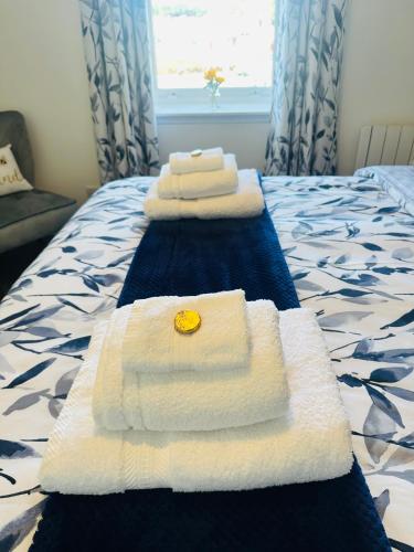 three towels sitting on top of a bed at Kilmartin Court Apartments - No3 By The Sea & No2 With A View - free parking in Oban