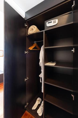 a closet with a black door with shoes in it at Hotel Tolosa in Puerto Madryn