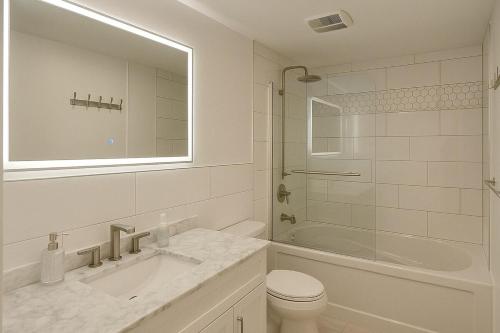 Un baño con lavabo, inodoro y ducha. en Chic 3BR Stay in Laval, Bright and Peaceful, en Laval
