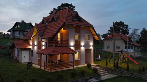 una piccola casa con un tetto in cima a un cortile di Apartmani Radovanović a Divčibare