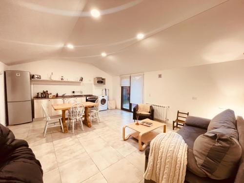 a living room with a couch and a table at Los Coirones 3 - Cabaña con jardin in Dina Huapi