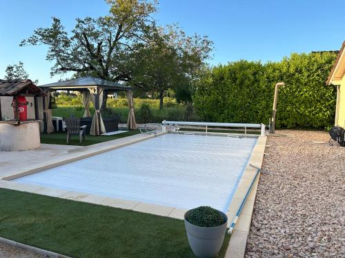a swimming pool in a backyard with a gazebo at Jolie Villa indépendante climatisée 3 chambres tout confort 6 couchages, piscine chauffée 4 X 8 disponible selon météo de Mai à fin Septembre, Jacuzzi 4 places, boulodrome éclairé, ping-pong, wifi, proche commerces Animaux domestiques sur demande in Bretenoux