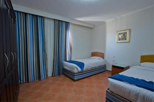 a hotel room with two beds and a window at Porto Marina majestic in El Alamein