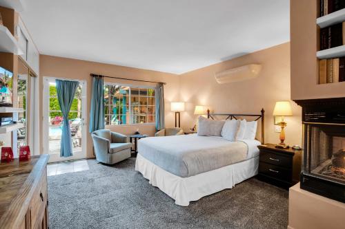 a hotel room with a bed and a fireplace at Coyote Inn - 21 and Over in Palm Springs
