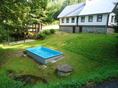 a blue pool in the yard of a house at Chata Tanvaldský Špičák in Tanvald