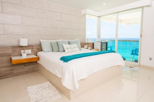 a bedroom with a large bed and a large window at Ocean View Modern Condo & Luxury Amenities in Cancún