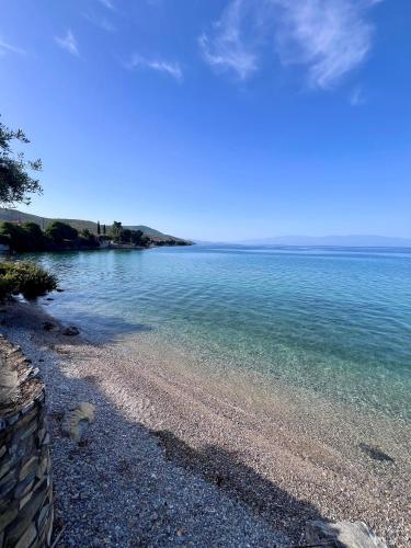 a beach with clear water and a rocky shore at Villas Nies Seaside Appartments in Soúrpi