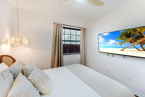 a bedroom with a bed and a tv on the wall at Waterfront Villa with Beach, Game Room, Cinema and Spa in Pembroke Pines
