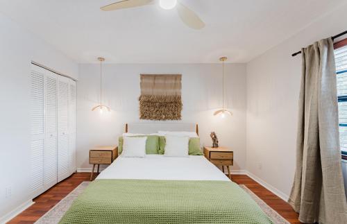 a bedroom with a large bed with a green blanket at Waterfront Villa with Beach, Game Room, Cinema and Spa in Pembroke Pines