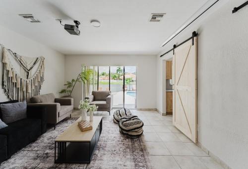 a living room with a couch and a table at Waterfront Villa with Beach, Game Room, Cinema and Spa in Pembroke Pines