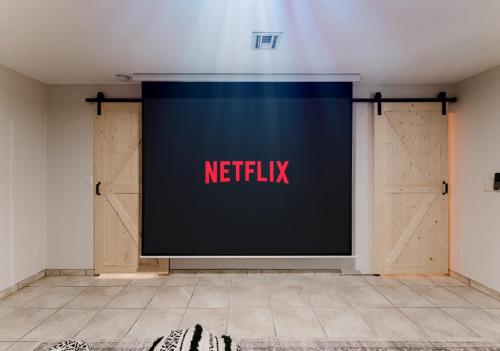 a large screen in a room with a netflix sign on it at Waterfront Villa with Beach, Game Room, Cinema and Spa in Pembroke Pines