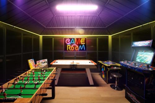 a gaming room with a table and arcade games at Waterfront Villa with Beach, Game Room, Cinema and Spa in Pembroke Pines