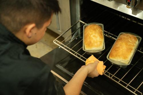 a man is taking two cakes out of an oven at Hotel con Corazon Monteverde in Monteverde Costa Rica