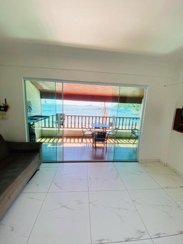 a room with a view of a table and a balcony at Estalagem pé na areia in Arraial do Cabo