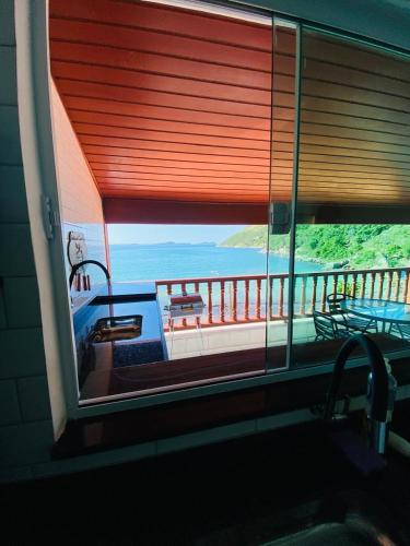 a window in a room with a view of the ocean at Estalagem pé na areia in Arraial do Cabo