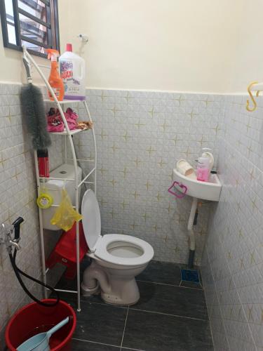 a bathroom with a toilet and a sink at Roomstay Floral in Sri Gading