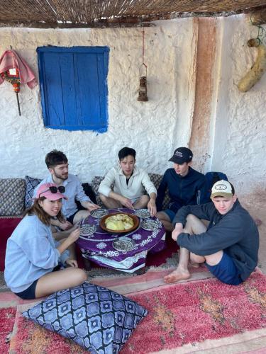 a group of people sitting around a table at Berber Waves Surf House in Tamraght Ouzdar