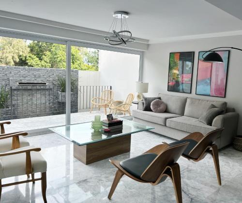 een woonkamer met een bank en een tafel bij Casa Loma next to Xochimilco in Oaxaca City