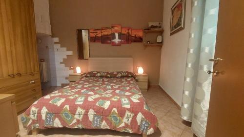 a bedroom with a bed and two lights on the wall at Suite 71 in Fusignano