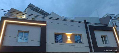 a white building with a window with lights in it at Residence Debbabi sans coupure d'eau in Monastir