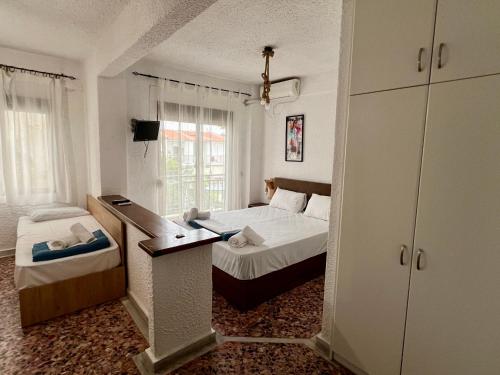 una piccola camera con un letto e una camera con un letto di una piazza di Pelekan rooms and apartments Athina 32 a Pefkohori