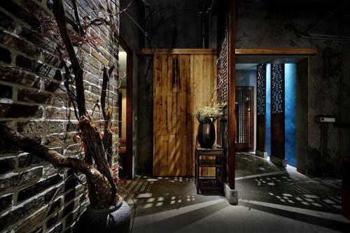 a hallway with a brick wall and a vase on a table at Huangshan Shanshuijian Wei Boutique Hotel in Huangshan