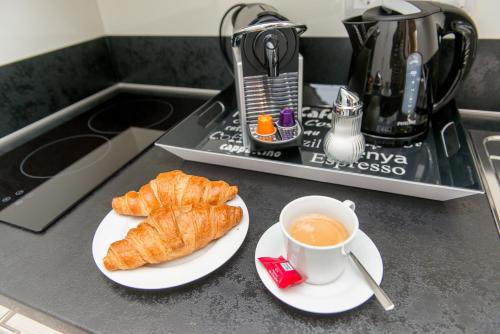 a cup of coffee and a croissant on a counter at Design-Apartments by Ulrike Horster in Bensheim