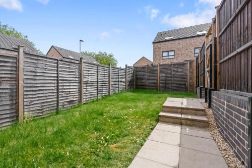 a fence in a yard with a grass field at Lotus Haus - Wellington Homes - 4 BDR With Gated Parking in Birmingham