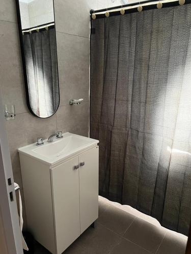 a bathroom with a sink and a shower with a mirror at Dpto Nación in San Nicolás de los Arroyos