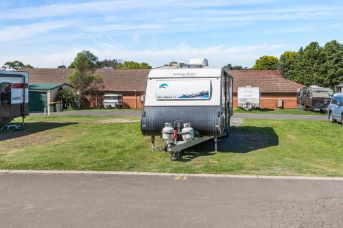 a trailer parked on the grass in a parking lot at Moss Vale Village Park in Moss Vale