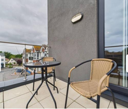 a balcony with a table and chairs and a window at Cooden Balcony Apartment in Bexhill
