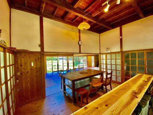 a dining room with a wooden table and chairs at SUNAORetreat奥白浜 in Minamiboso
