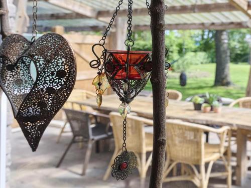 a hanging bird feeder with a heart hanging from a tree at Bouwhoeve in Elsendorp