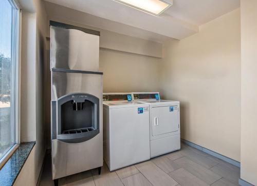 a kitchen with a refrigerator and a washer and dryer at Holiday Inn Express San Diego - Sorrento Valley by IHG in Sorrento
