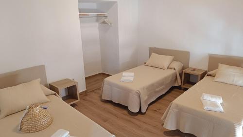 a room with two beds and two tables at Apartamento La Andana in Jerez de la Frontera