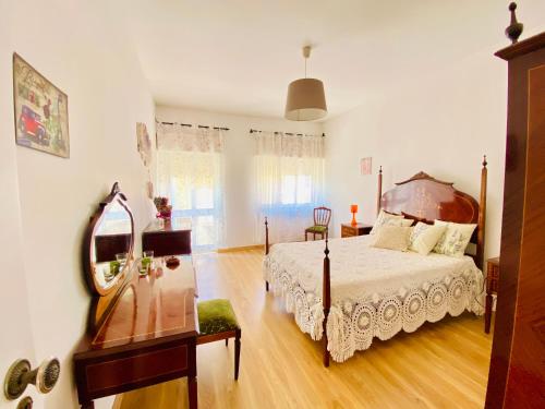 una camera da letto con un letto grande e uno specchio di Bia Vintage Villa - Casa com Vista Mar, Terraço e Jardim no Centro de Alvor ad Alvor