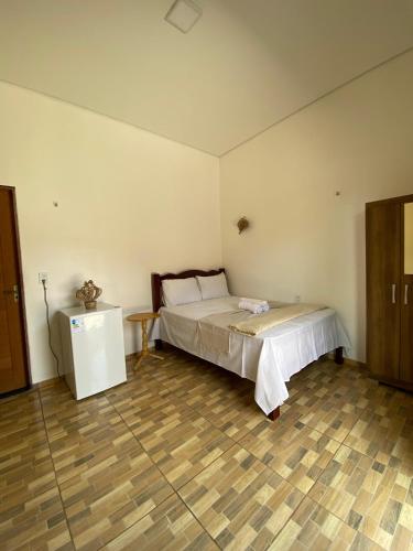 a bedroom with a bed and a wooden floor at Casa da Andrea 02 in Barreirinhas