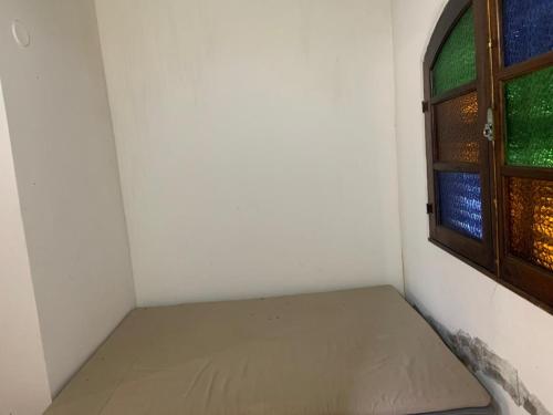 a small room with a mattress next to a window at Casa na subida da Serra de Friburgo com Cachoeira in Cachoeiras de Macacu